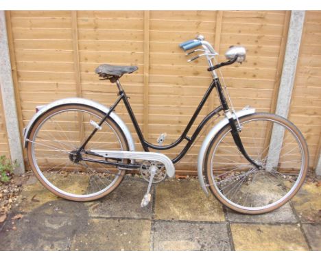 An early 20th century Peugeot lady's bicycle: the black step through frame with silver painted bars, bar brakes, single speed