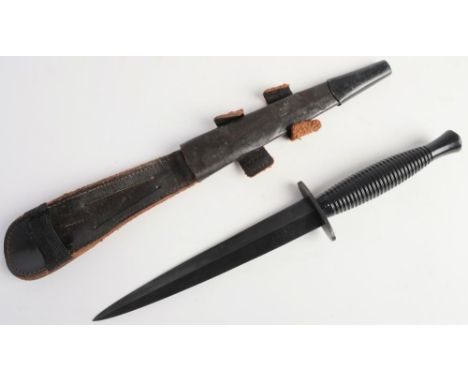 A Fairbairn Sykes pattern fighting knife: straight double edged blade over one piece hilt and  cast ribbed grip, in a black l