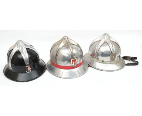 Three Austrian Fire Service aluminium helmets: all with six pointed comb and enamel badges to front, two with rank stripes, t