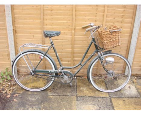A 1960s  BSA Shopper bicycle: green step through frame ,chrome plated handlebars, bar rakes, three speed gears, front pannier