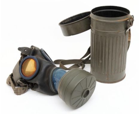 A WWII period German GM30 gas mask: black rubber mask with blue metal mounted glass lenses and canvas straps, pre-war ordnanc