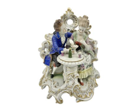Figure group, probably Volkstedt, modelled as a courting couple seated before a table, the ornate bench and table conforming 