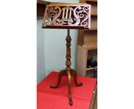 A Regency design duet music stand, pierced mahogany adjustable platforms, with gilded column motifs, raised upon a turned ste