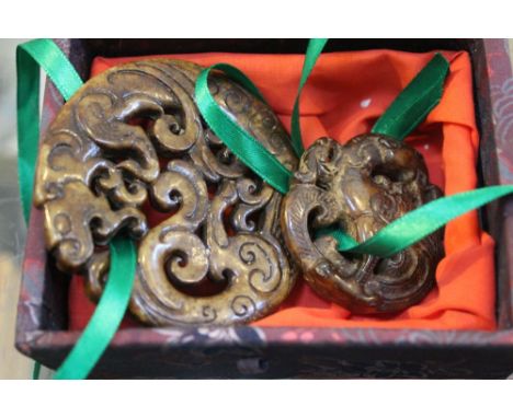 Twin jade carved pendants, the larger with dragon design &amp; second with a phoenix