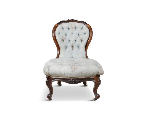 A VICTORIAN LADY'S ROSEWOOD FRAMED BALLOON BUTTON BACK SALON CHAIR, with carved crest rail and raised on leaf carved cabriole