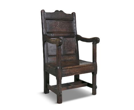 A CHARLES II OAK AND ELMWOOD WAINSCOT CHAIR, 17th Century with flat panelled back and arched top rail, open scrollwork arms a