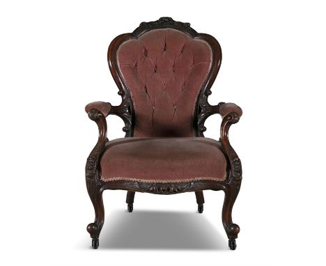A VICTORIAN MAHOGANY FRAMED UPHOLSTERED BUTTON BACK ARMCHAIR, with arched padded back and stuffed seat, with scrolling armres