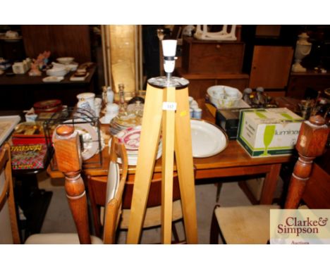 A tripod standard lamp lacking shade