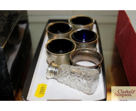 A silver topped jar; a silver napkin ring; and a set of four plated salts with blue liners 