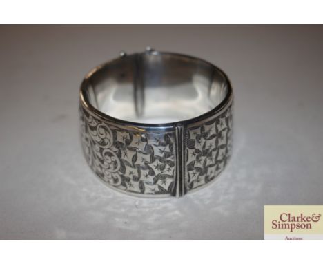 A wide silver hinged bangle with chased foliate decoration, Birmingham 1944