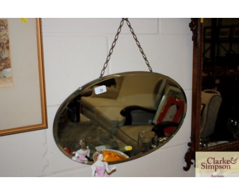 A frameless bevel edged wall mirror together with a wall clock and a pencil signed print