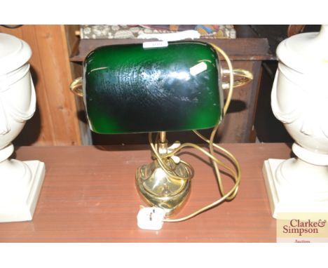 A brass desk lamp with green glass shade