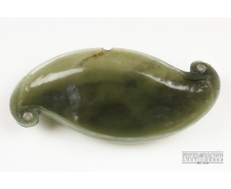 A Mughal spinach green jade dish, of leaf form with scrolled terminals, the underside carved with stylised leaves with scroll