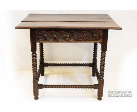 An 18th century oak side table, with bobbin legs and supports, the single drawer with heavily carved detail, plank top, 84.5 