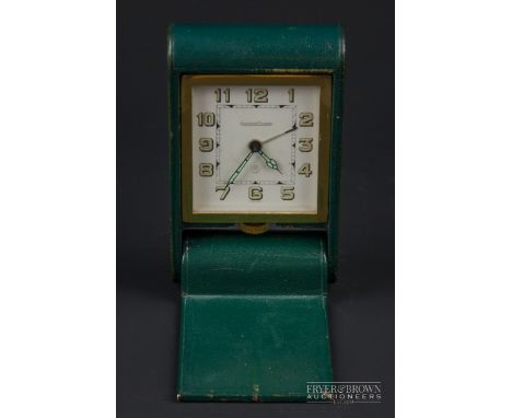 An Art Deco Jaeger Le Coultre travelling alarm clock, the rectangular dial with fluorescent hands, in original green leather 