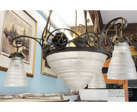 A French Art Deco metalwork light fitting finely worked with roses and stiff leaves, the central clear frosted glass shade by