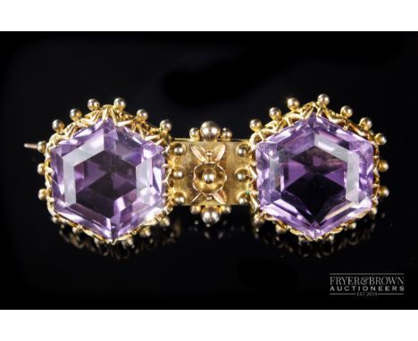 An antique amethyst and gold brooch, c1890, set with two step cut hexagonal amethysts in coronet and bead openwork mount