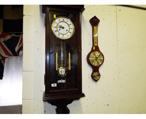 A contemporary wall clock, mechanical movement, Roman numerals with pendulum and key, included in the lot a modern thermomete