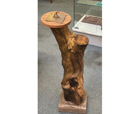 Brass sundial mounted on a rustic wooden pedestal