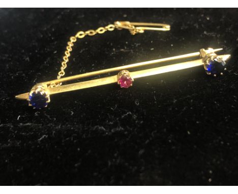 Yellow metal brooch set with 2 sapphires & ruby Weight 3.4g