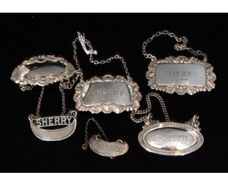 Six assorted hallmarked silver decanter labels, four sherry, a Brandy and a presentation example, various dates and styles. (