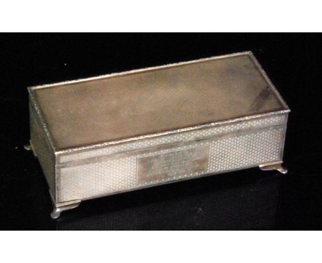 A hallmarked silver rectangular cigarette box, cedar lined, with engine turned decoration, cast foliate border and presentati