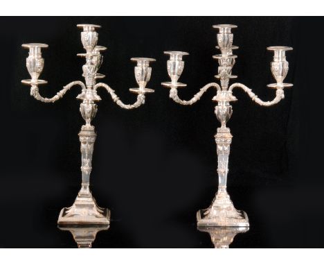 A pair of silver plated four light candelabras, each with four urn shaped scones having a ribbon and mask decoration, detacha