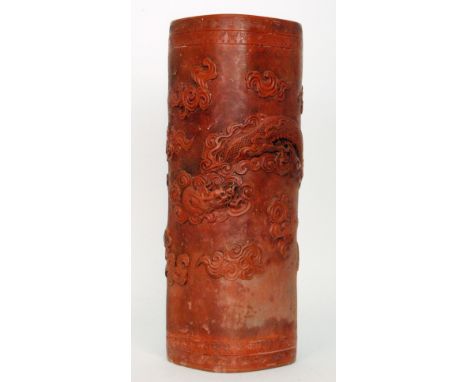 An early 20th Century Chinese terracotta stick stand of squared cylindrical form decorated with relief moulded dragons amidst