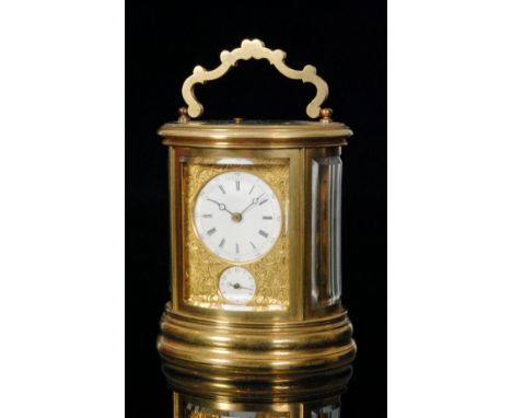A late 19th Century French oval brass carriage clock the circular dial with subsidiary dial with push button repeat within a 