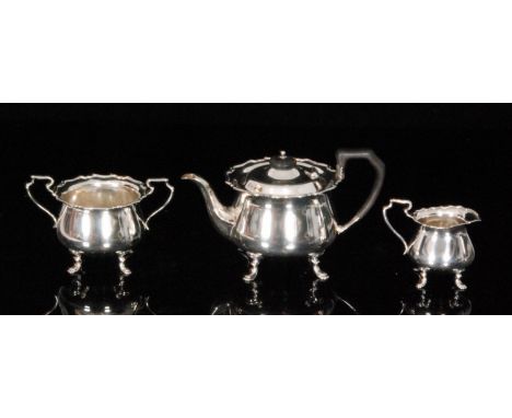 An Edwardian hallmarked silver three piece tea service comprising of teapot, milk jug and sugar bowl, each of plain squat cir