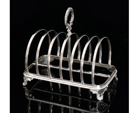 A Victorian hallmarked silver six division toast rack with beaded cast loop handle, conforming beaded base and raised on four