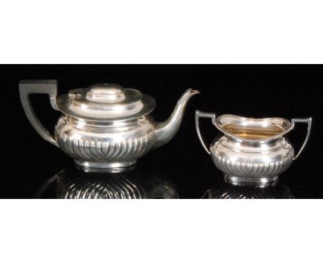 A hallmarked silver boat shaped bachelor's teapot with part fluted decoration, together with a matched sugar basin, total wei