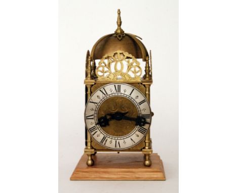 A small 17th Century style brass lantern clock the spring driven movement striking on a bell behind a silvered chapter ring o