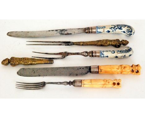 An early 19th Century knife and fork, the ivory handles each carved with three mitred bishops together with a Delft style kni