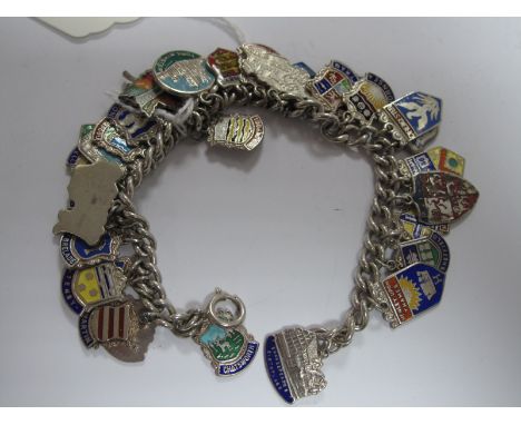 A Curb Link Charm Bracelet, suspending numerous souvenir enamel shield pendants etc. 