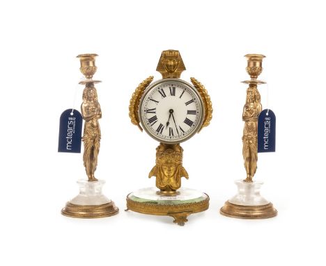 SMALL GILT METAL MANTEL CLOCK, with sphinx head mount, on a mirrored circular base, 26 cm high; along with a pair of gilt met