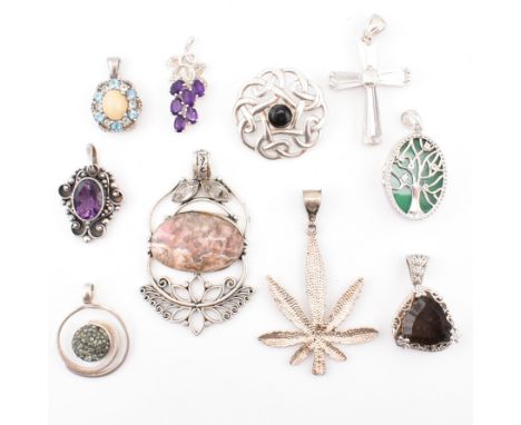 A collection of silver and gem set necklace pendants and a brooch pin. The lot to include gem set pendants, pendant in the fo