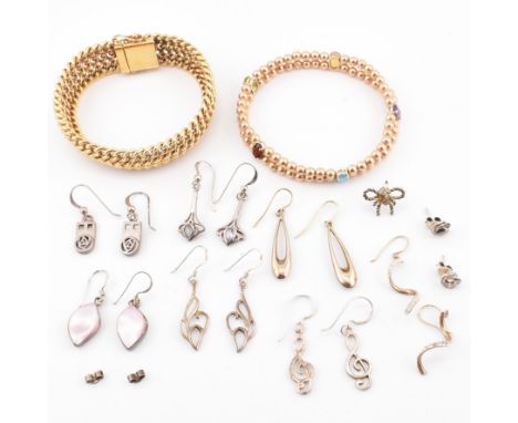 A collection of silver earrings and two yellow tone metal bracelets. The eight pairs of earrings to include silver and gem se