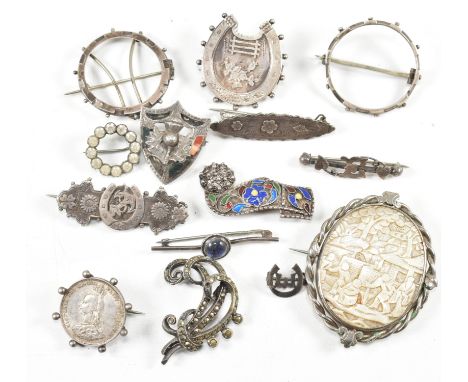 A collection of silver and white metal brooch pins. The brooches to include a large carved 19th century mother-of-pearl orien