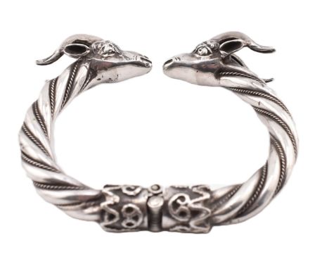 A white metal rams head torque bangle. The bangle having rams head finials with rope twist hinged bangle. The bangle unmarked