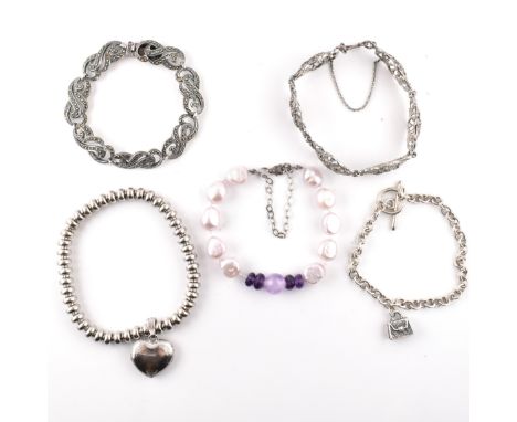 A collection of silver and gem set bracelets. The lot to include a hallmarked silver charm bracelet with a single handbag cha