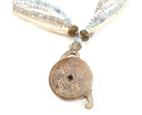 Barbara Acton Bond - A carved nephrite jade pendant necklace. The necklace strung with a nephrite jade carved pendant strung 
