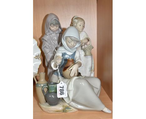 A LLADRO FIGURE AND TWO NAO FIGURES, comprising Lladro Woman Painting no 5079, sculptor Juan Huerta, issued 1980-1985, height