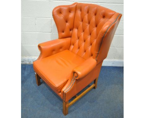 A BLOOD ORANGE LEATHER WING BACK ARMCHAIR, with button back, and swept armrests, width 80cm x depth 78cm x height 107cm, cond
