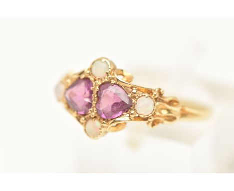 A YELLOW METAL AMETHYST AND OPAL RING, set with two heart cut amethysts and four small opal cabochons, set within a scrolling
