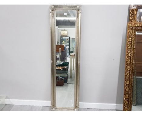 A MODERN SILVER WALL MIRROR WITH SILVER SWEPT FRAME 167 X 44CM