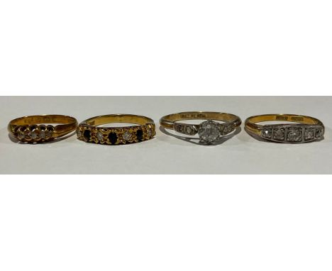 An 18ct gold and diamond five-stone ring; the large central stone flanked by four further graduating stones, size L/M; an 18c