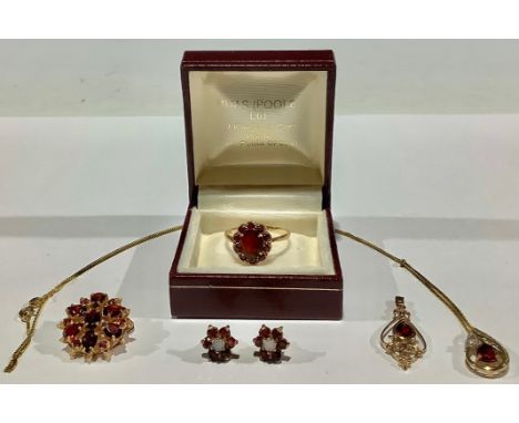 A composed suite of 9ct gold and garnet jewellery, comprising, a 9ct gold brooch set with a flower head arrangement of facete