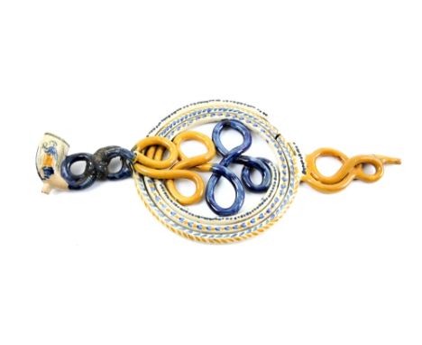 Early 19th Century English Prattware coiled pipe in blue and ochre, the bowl modelled with two figures in trousers.  Mouthpie