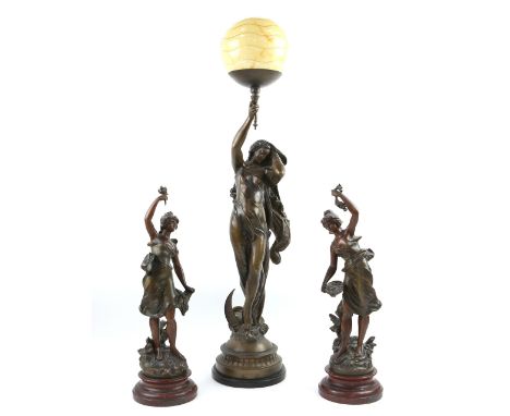 Spelter figural lamp in the form of a woman holding a torch, 90cm and a pair of spelter  figures of women, 50cm   .   Lamp in